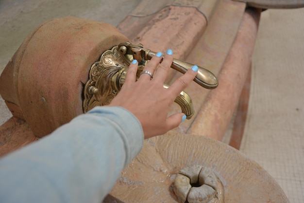 Robinet vintage avec source d'eau minérale et main de femme