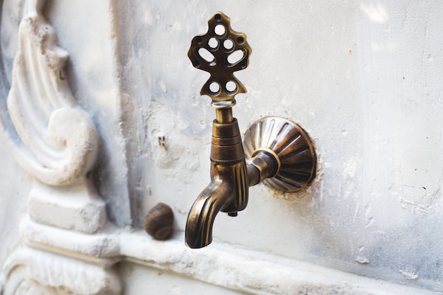 Photo robinet vintage de style ottoman turc à la fontaine d'ablution dans la cour.