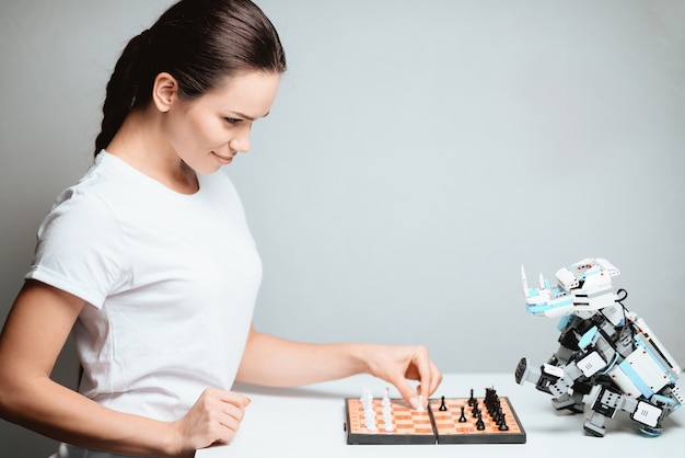 Le robot est assis en face d&#39;elle sur la table