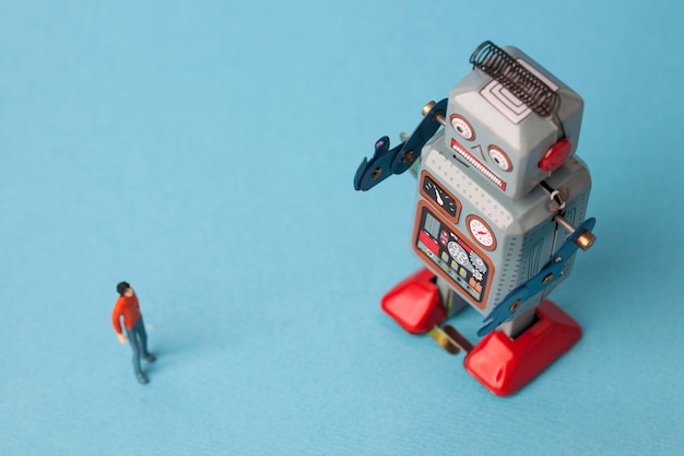 Photo robot étain jouet avec homme sur fond bleu