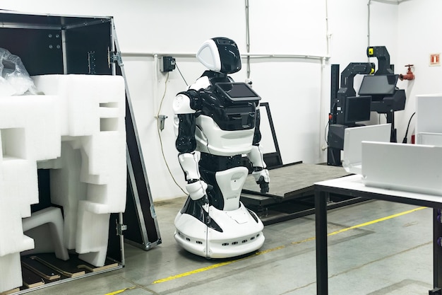 Photo un robot humanoïde nouvellement assemblé dans un atelier est chargé avant d'être emballé