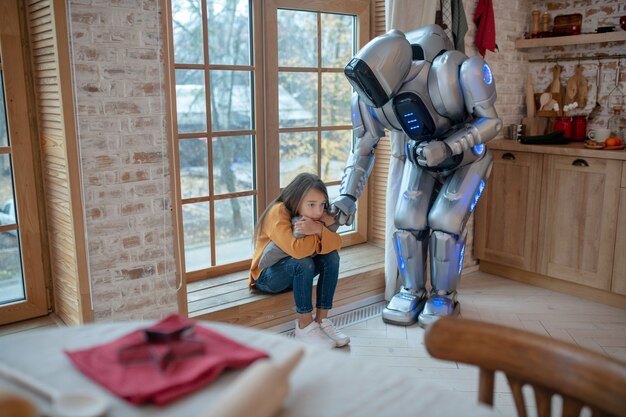 Robot Parlant à La Fille Assise à La Fenêtre