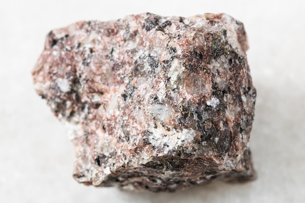 Roche de granit rose rugueux sur marbre blanc