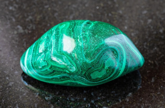 Photo roche de malachite roulée sur le noir