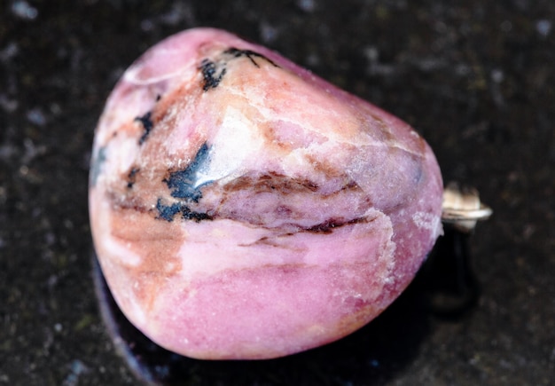 Roche roulée de Rhodonite sur le noir