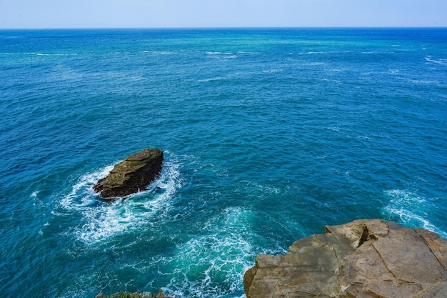 Rocher sur l'océan avec des vagues entourant Pacitan East Java Indonésie