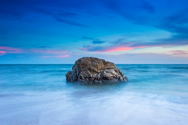 Photo des rochers dans la mer contre le ciel au coucher du soleil