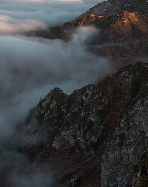 Rochers de pointe dans les nuages épais au coucher du soleil en automne