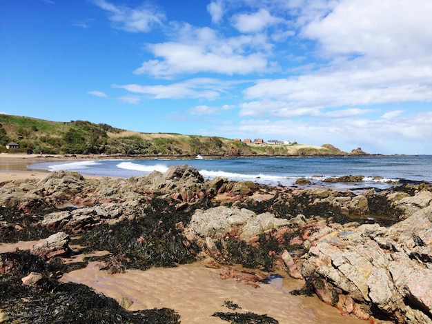 Des rochers sur le rivage contre le ciel bleu