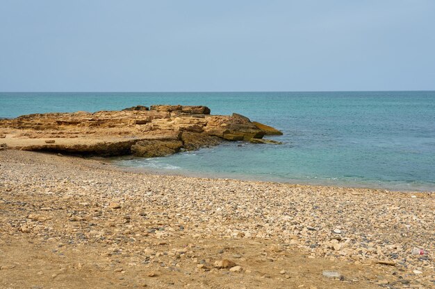 Rochers et vagues sur une plage tropicale sablonneuse