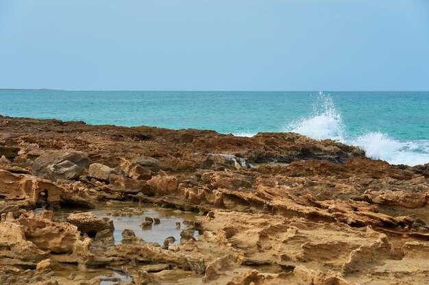 Rochers et vagues sur une plage tropicale sablonneuse