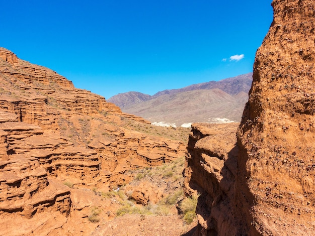 Roches rouges et passage entre les rochers Canyons d'argile Région d'IssykKul au Kirghizistan Voyage et tourisme