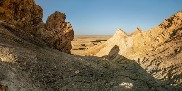 Roches sèches près de l'oasis de Chebika avec désert en arrière-plan éclairé par le soleil de midi. Montagnes de l'Atlas, Tunisie.