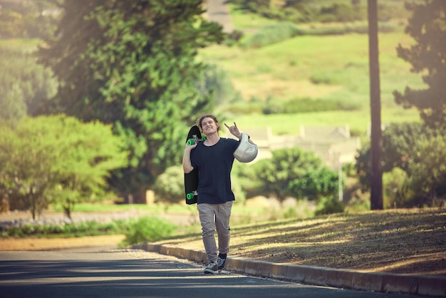 Rock insouciant et portrait d'un homme avec une planche à roulettes pour le plaisir de la liberté et le sport urbain dans la rue Bonne planche à roulettes branchée et hipster sur la route pour l'activité physique dans la nature de la Norvège