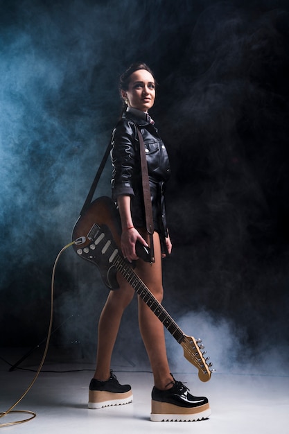 Photo rock star femme avec guitare électrique sur scène