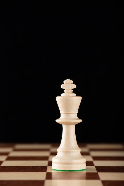 Roi d'échecs léger sur un échiquier en bois Leadership, combattant, compétition, concept de confrontation.