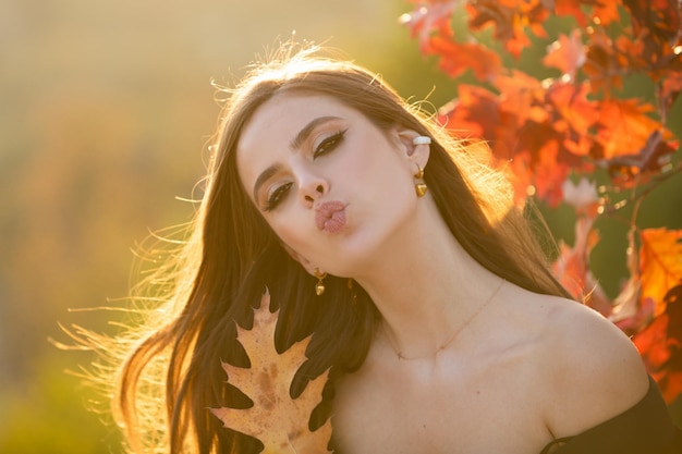 Romance d'automne femme avec des feuilles modèle féminin sur le rêve du jour du feuillage et le port extérieur de beauté de style de vie