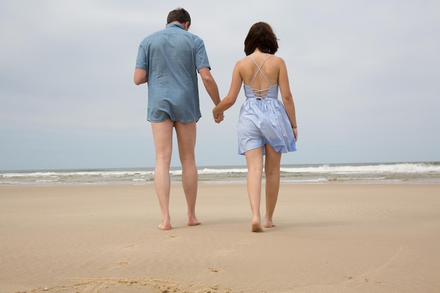 Romantique couple d'amoureux d'âge moyen marchant sur la plage