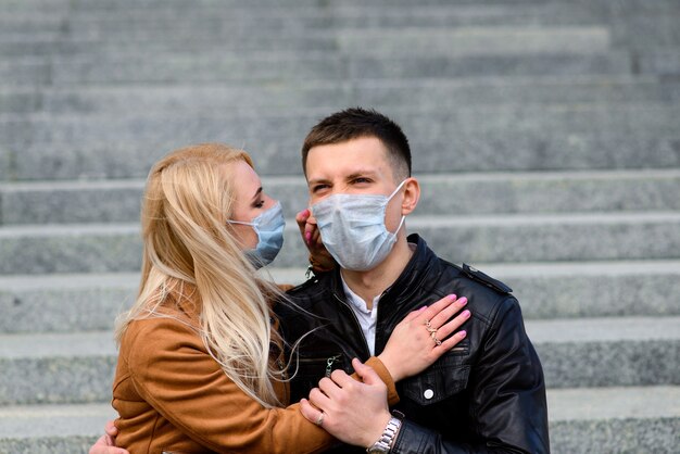 Romantique jeune beau couple appréciant le temps ensemble portant des masques de protection