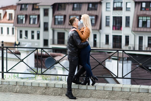 Romantique jeune beau couple appréciant le temps ensemble portant des masques de protection