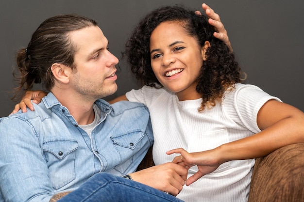 Romantique jeune couple heureux homme caucasien et femme afro-américaine sourient et s'amusent ensemble le jour de la saint-valentin sur fond noir