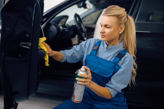 La rondelle femelle avec une éponge nettoie la garniture de porte automobile, le service de lavage de voiture Femme lave un véhicule, station de lavage de voiture, entreprise de lavage de voiture