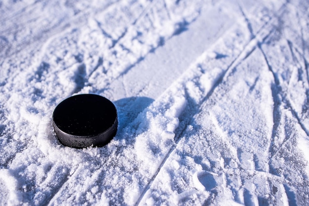 La rondelle de hockey se trouve sur le gros plan de la neige