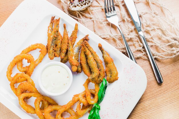 Photo rondelles d'oignon frites avec poisson frit, service à bière