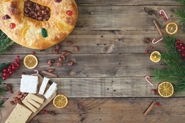 Rosca de Reyes sur un socle en bois avec des décorations de Noël