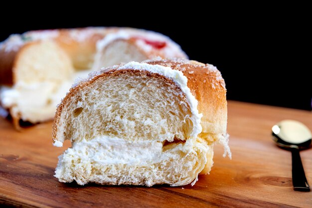 Roscon de reyes farci à la crème, typique de l'Espagne le jour des Rois Mages avec portion vue de près