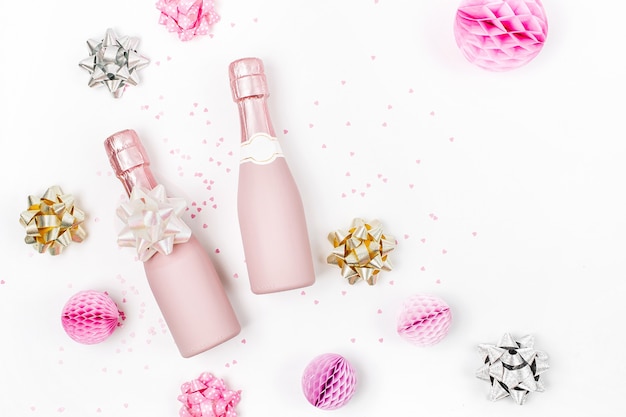 Rose pâle Mini bouteilles de champagne avec confettis et guirlandes. Mise à plat. Nouvel an/Célébration de Noël ou thème du concept de mariage. Mise à plat, vue de dessus