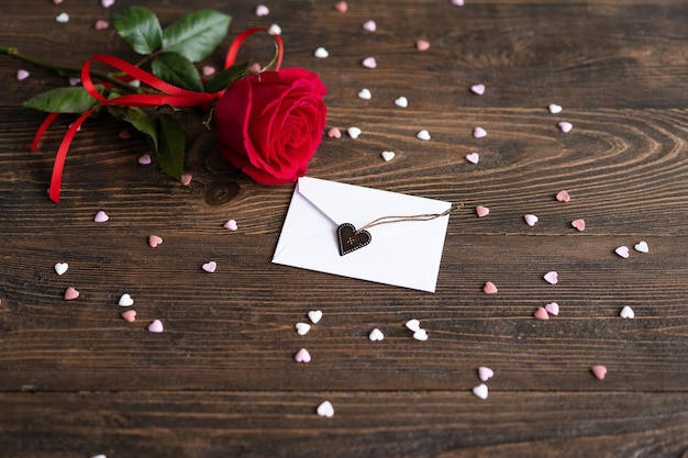 Rose rouge avec carte postale sur fond en bois Carte postale Happy Valentines Day Concept d'amour pour la fête des mères ou la Saint Valentin Carte de Saint Valentin avec un espace pour le texte