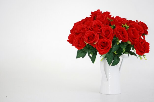 Rose rouge dans un vase blanc sur blanc