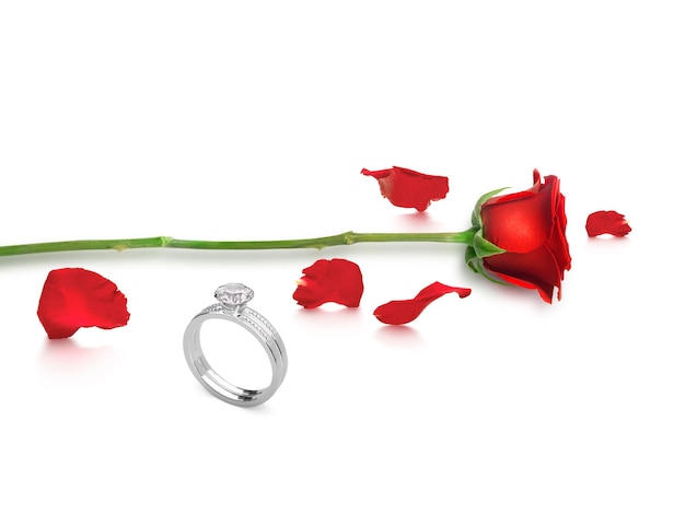 Rose rouge avec une élégante bague en diamant sur fond blanc