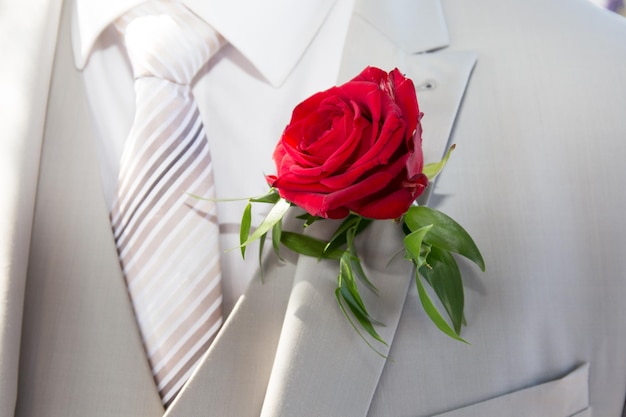 Rose rouge sur la veste de costume du marié