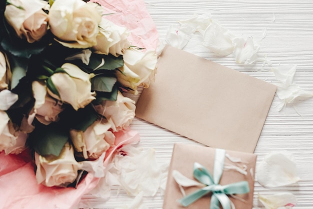 Roses blanches avec carte vide et boîte-cadeau sur l'espace de fond en bois pour le texte Maquette de carte de voeux florale Invitation de mariageconcept de fête des mères heureuse Saint-Valentin