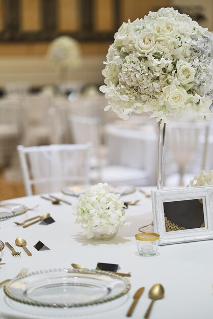 Photo des roses blanches dans un vase sur la table.