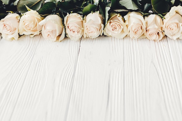 Photo roses blanches sur fond en bois copiez l'espace pour le texte carte de voeux florale faire-part de mariage ou concept de bonne fête des mères bordure élégante de fleurs blanches bonjour printemps