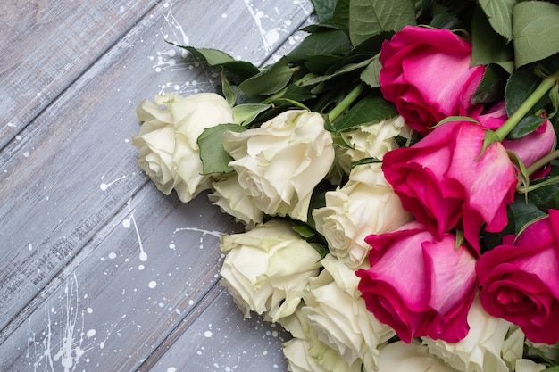 Roses blanches sur une table grise et rose.