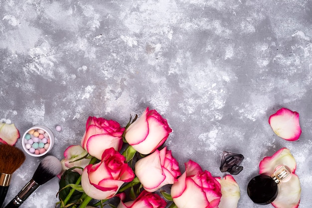 Roses et cosmétiques décoratifs comme cadre