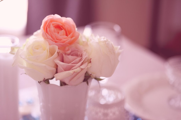 Des roses dans un vase sur la table à la maison.