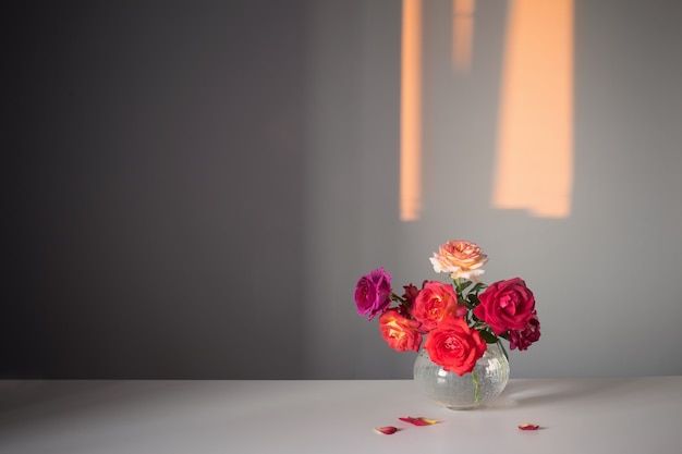 Roses dans un vase en verre sur fond gris