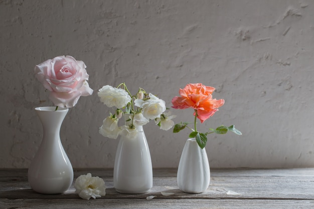 Roses dans des vases blancs sur fond ancien