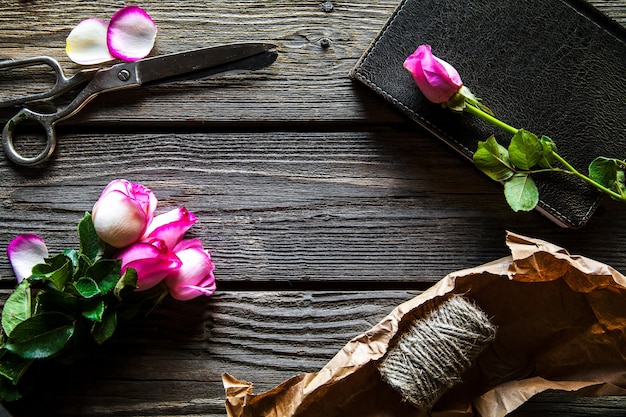 Roses fraîches avec agenda et tasse de café sur une table en bois, vue de dessus. fleurs, boisson chaude