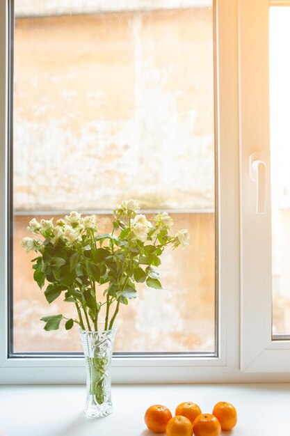 Roses avec des mandarines sur le rebord de la fenêtre Mode de vie sain et beau Idées de maison confortables