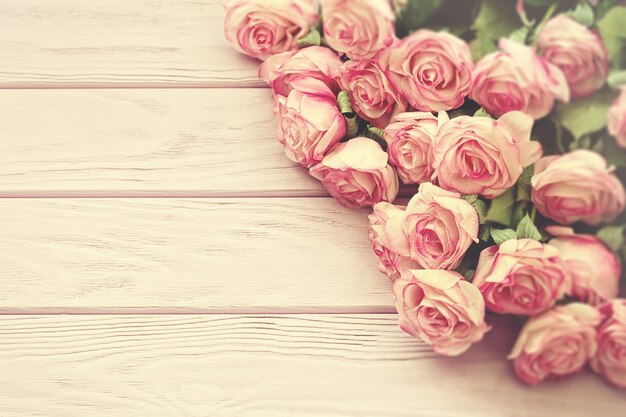 Roses rose clair sur une surface en bois