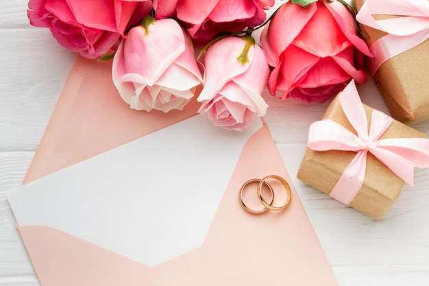 Roses roses et anneaux de mariage sur enveloppe