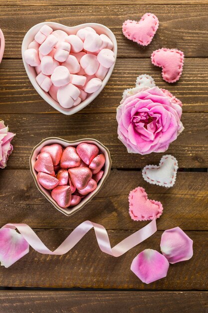 Photo roses roses avec des chocolats sur table en bois rustique.