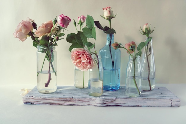 Roses roses fraîches dans des vases transparents en verre, fleurs pour les salutations romantiques, joyeux anniversaire