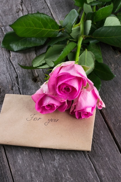 Roses roses et message sur fond sombre